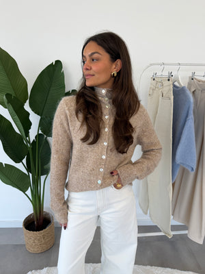 Seraya vestje – fijngebreid damesvest met knoopsluiting, schuin vooraanzicht in beige/bruin tint