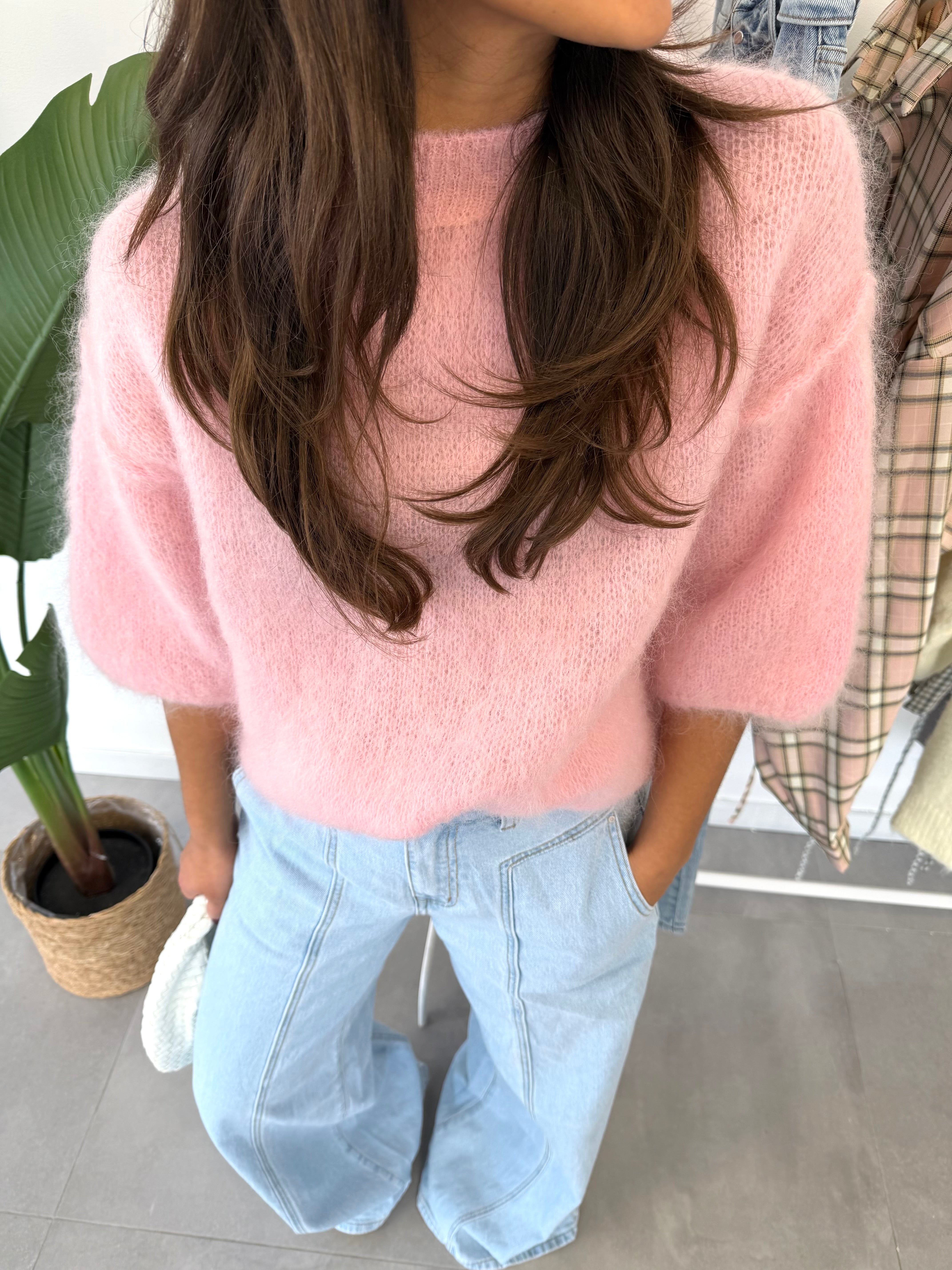 Rosie trui & blauwe jeans – roze trui met middellange mouwen en zachte stof, gecombineerd met blauwe jeans, close-up vooraanzicht